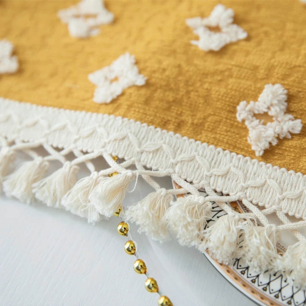 Allsidig gul duk med broderi og dusker