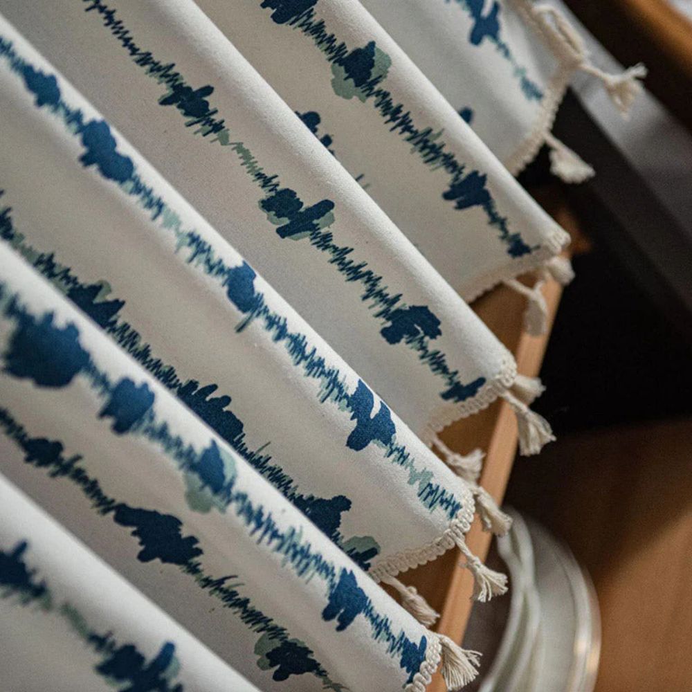 Blå skapgardin med blekkflekkmønster og dusker