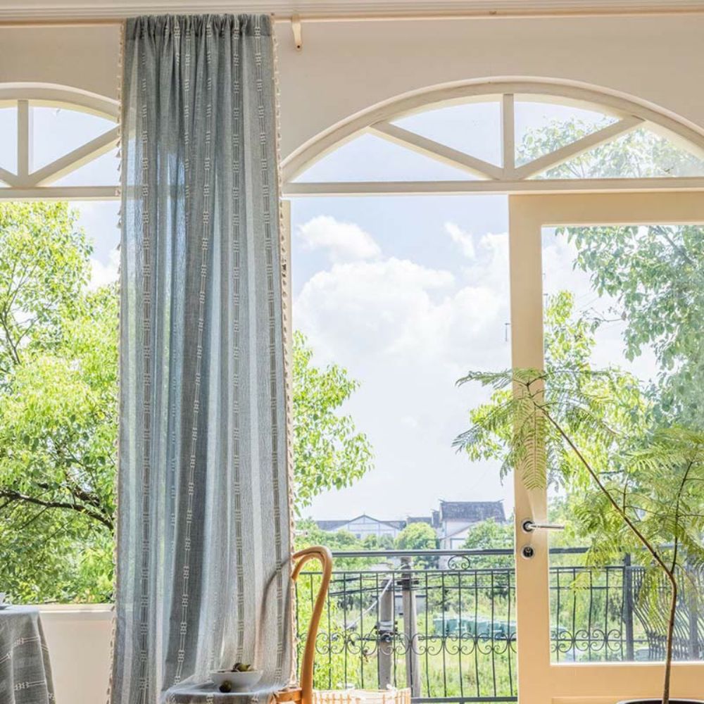 Transparent gardin med solstriper og dusker