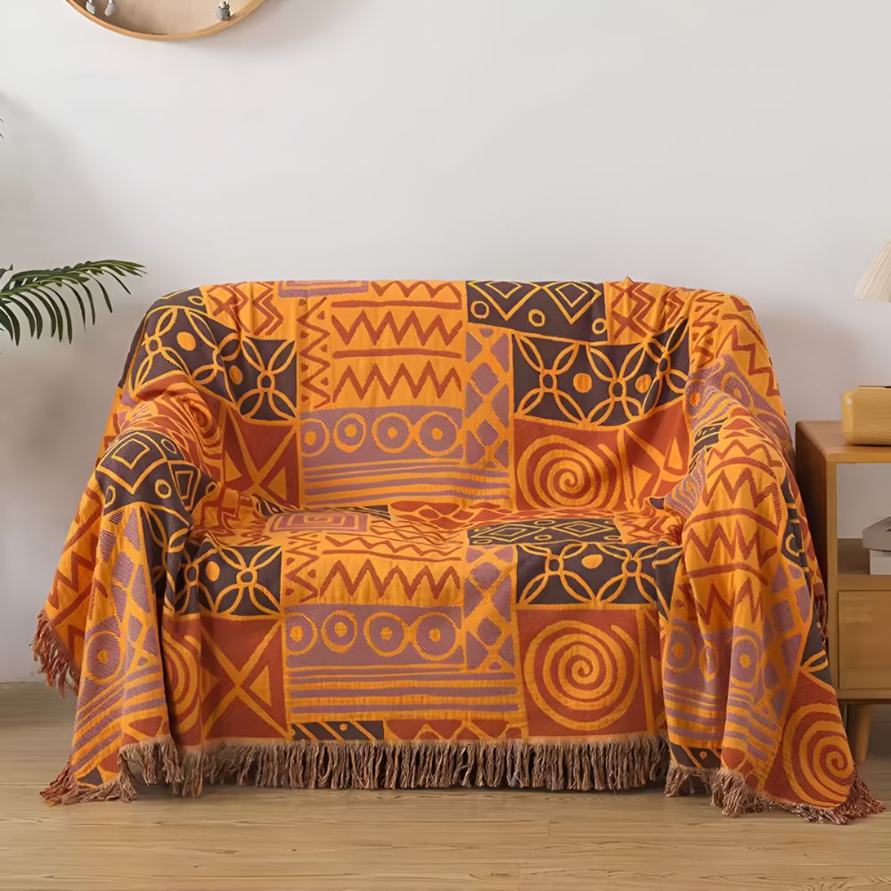 Vendbart bomullspledd med tribal patchwork og dusker