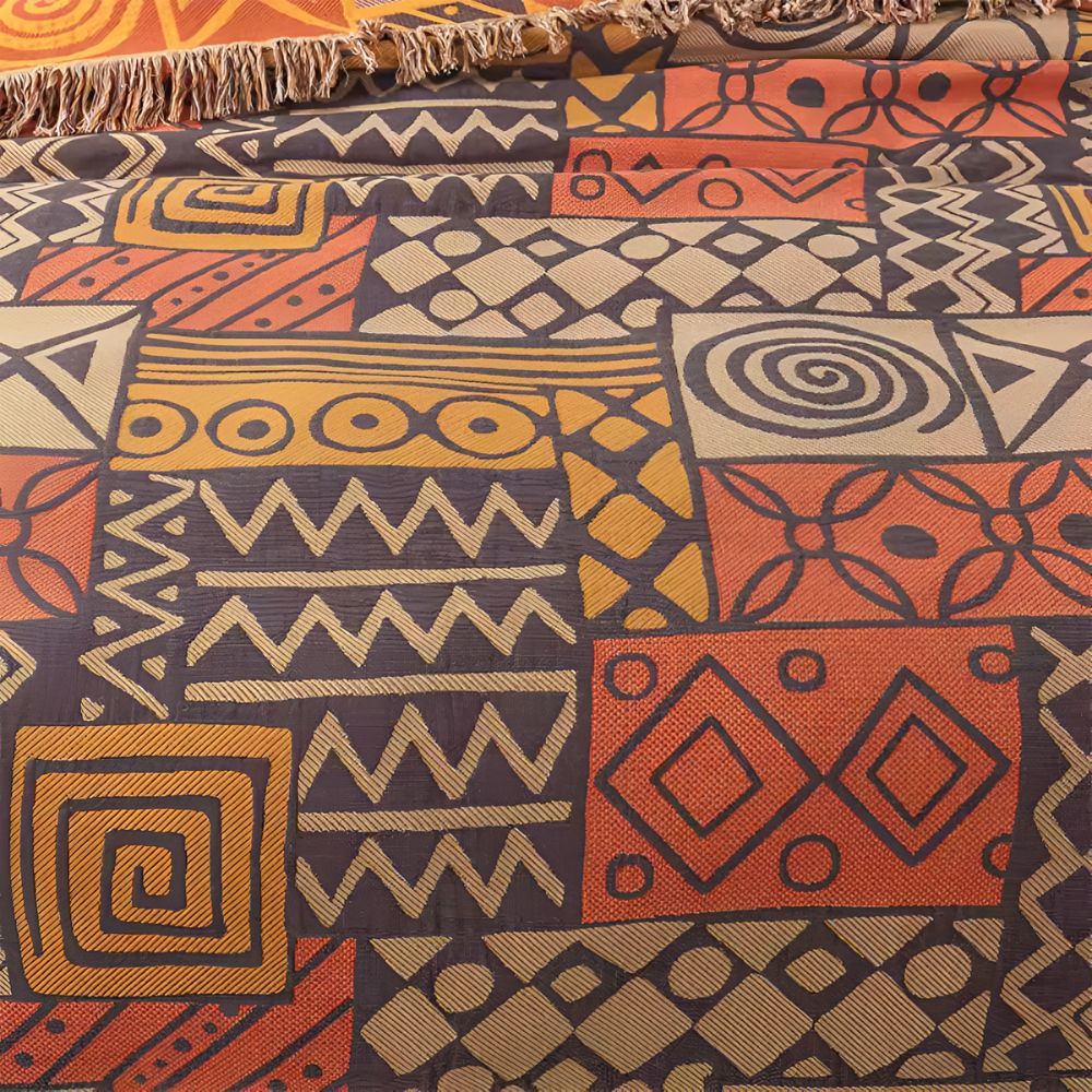 Vendbart bomullspledd med tribal patchwork og dusker