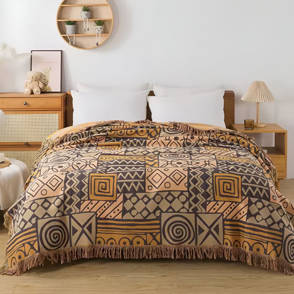 Vendbart bomullspledd med tribal patchwork og dusker